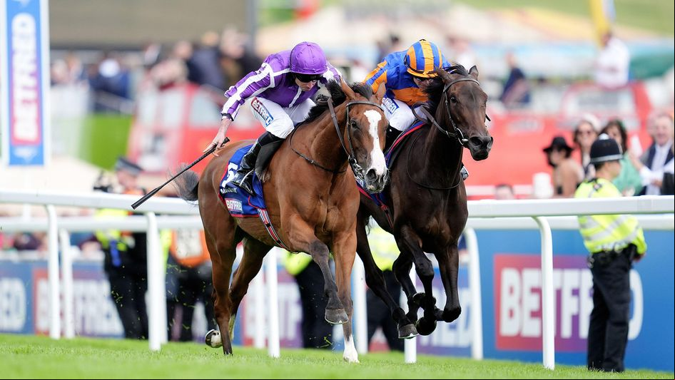 Minnie Hauk, ridden by Ryan Moore (left), wins the Oaks from Whirl