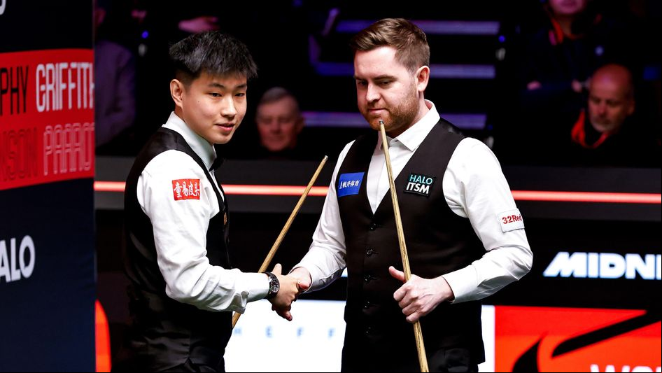 Zhao Xintong shakes hands with Jak Jones at the Crucible